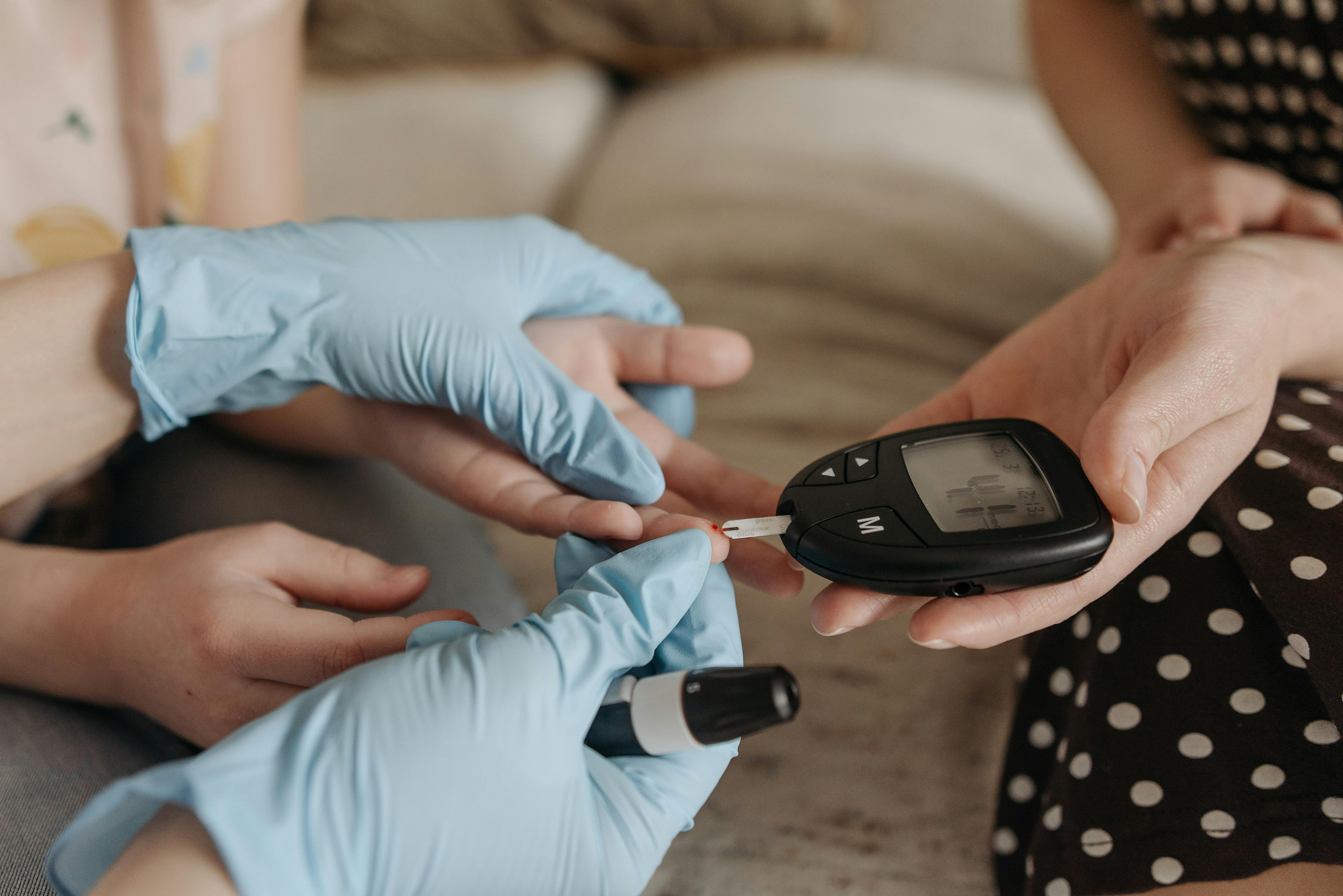 Healthcare provider testing patient's blood sugar levels for diabetes management